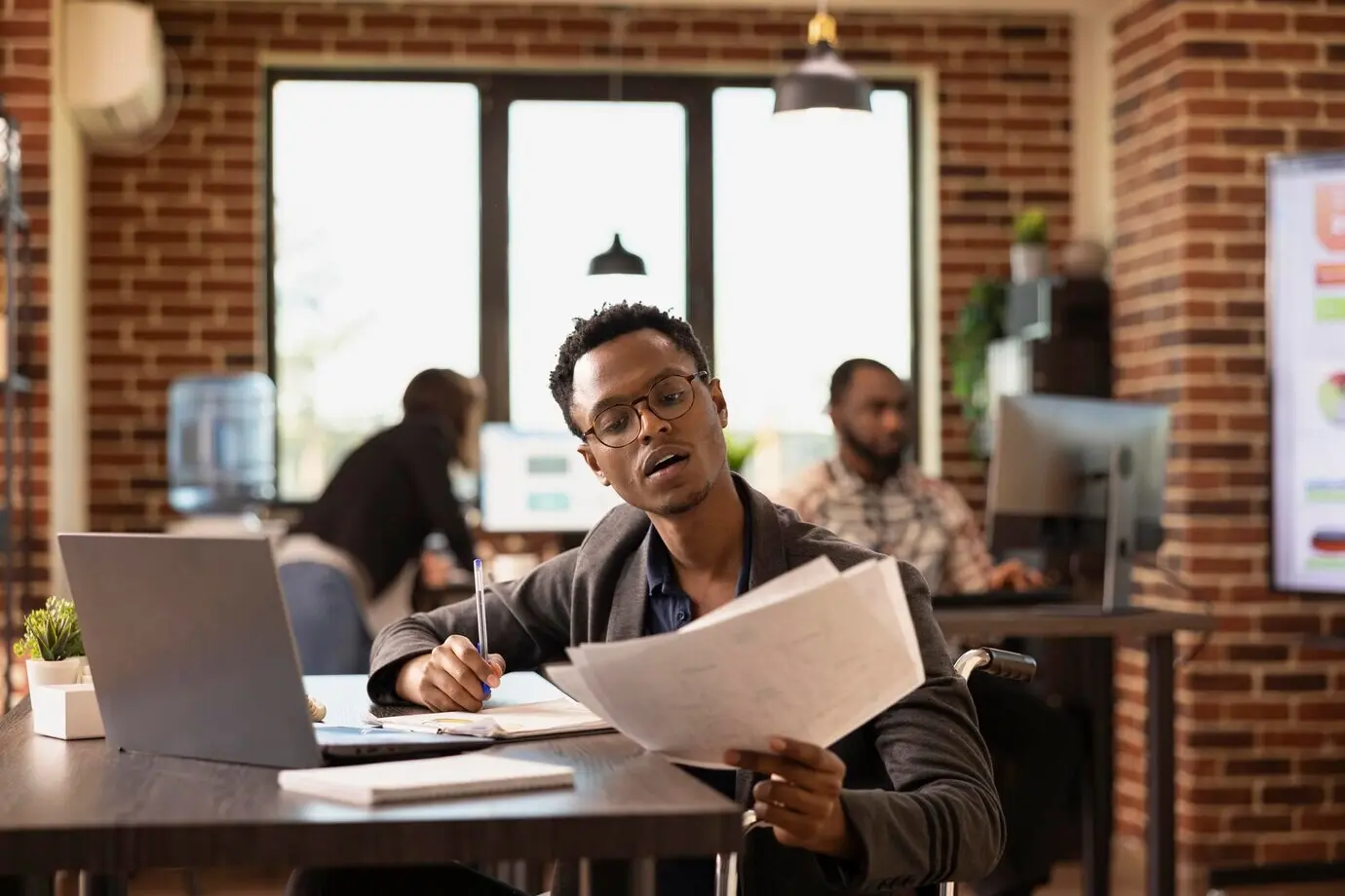 Männlicher Mitarbeiter hält Firmendokumente